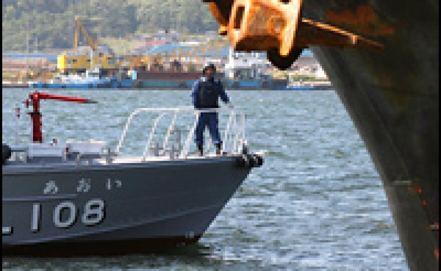 A Japanese Coast Guard boat stands watch as North Korean ship loads a cargo of used bicycles and refrigerators at the Maizuru port in Japan.