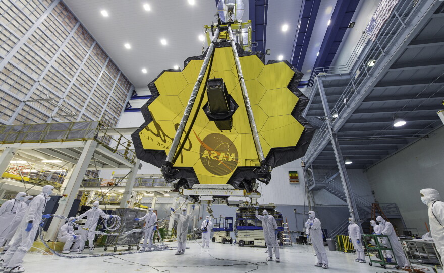 Technicians lift a mirror of the James Webb Space Telescope using a crane at  Goddard in 2017.