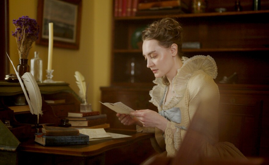 Maria Anna Mozart (Alyona Popova) at a desk reading a letter.