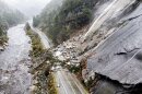 FILE - Rocks and vegetation cover Highway 70 following a landslide in the Dixie Fire zone on Oct. 24, 2021, in Plumas County, Calif. 