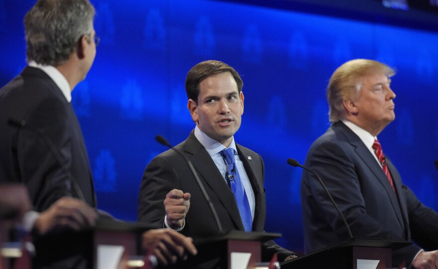 Marco Rubio (center) was able to stand out even while being targeted by Jeb Bush (left), someone once described as a mentor. Donald Trump looks on.