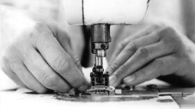 Photo of hands working on a sewing machine. 