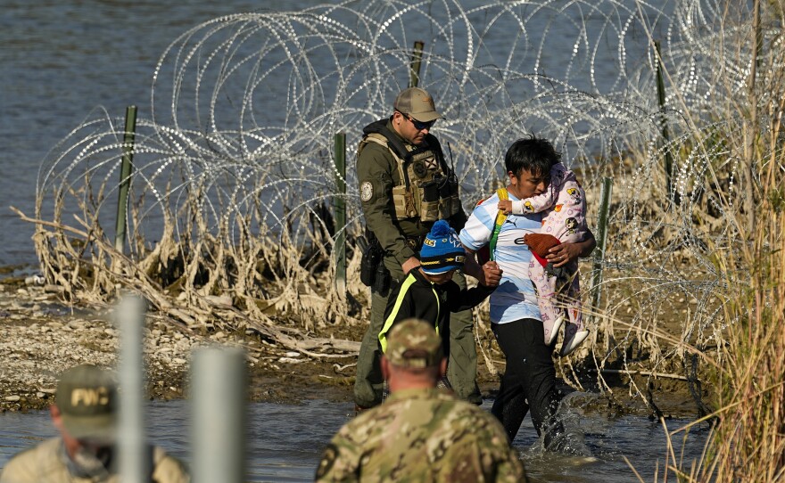 Migrants are taken into custody by officials at the Texas-Mexico border, Jan. 3, 2024, in Eagle Pass, Texas.
