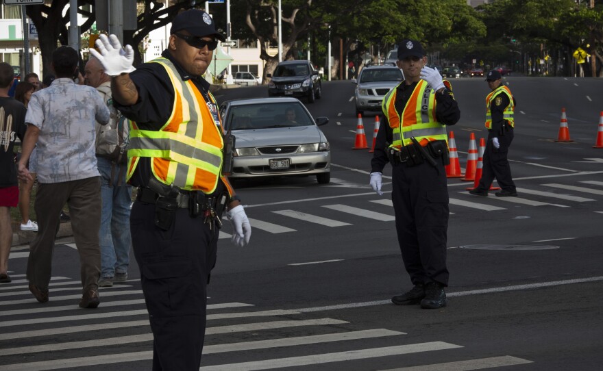 Honolulu police officers direct traffic at an intersection. Honolulu is the first major U.S. city to ban texting while walking in a crosswalk.