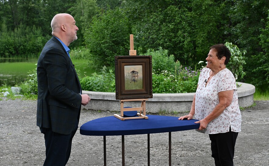 Alasdair Nichol (right) appraises a Sydney Laurence "Indian Fish Cache" oil, ca. 1922, in Anchorage, Alaska. ANTIQUES ROADSHOW “Alaska Native Heritage Center, Hour 1” premieres Monday, January 8 at 8/7C PM on PBS.