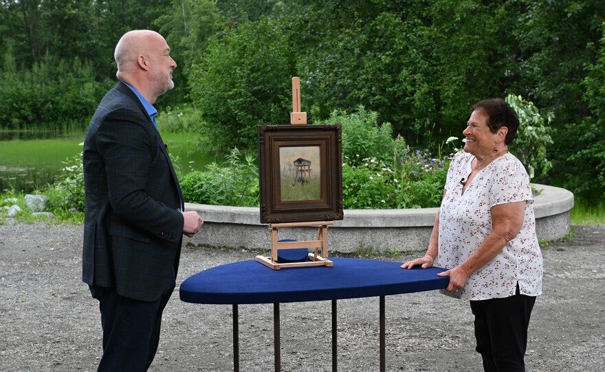 Alasdair Nichol (right) appraises a Sydney Laurence "Indian Fish Cache" oil, ca. 1922, in Anchorage, Alaska. ANTIQUES ROADSHOW “Alaska Native Heritage Center, Hour 1” premieres Monday, January 8 at 8/7C PM on PBS. 