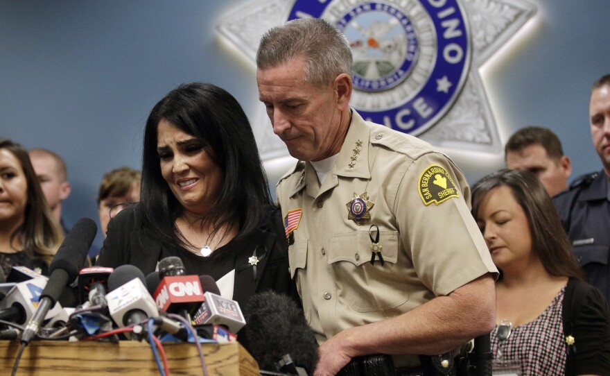 San Bernardino County Sheriff John McMahon comforts dispatcher Michelle Rodriguez during a news conference with the first responders who talked about their experiences in last week's terrorist attack.