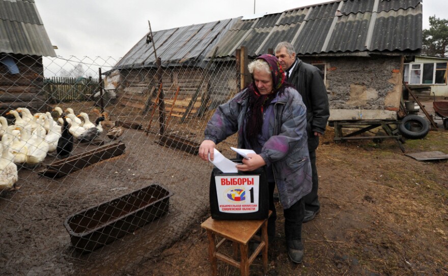 A Russian woman votes Sunday at a mobile ballot box in the western village of Shelomets. Prime Minister Vladimir Putin's United Russia party received around half the vote and will control the next parliament, but its majority was significantly reduced.