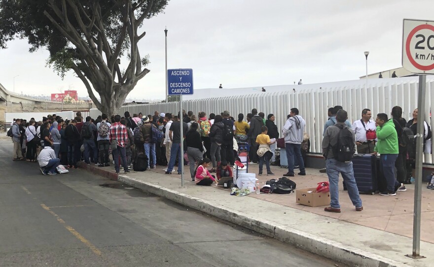 Asylum seekers in Tijuana, Mexico, listen to names being called from a waiting list to claim asylum at a border crossing in San Diego on Sept. 26.