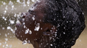 Miniimah Rashid, 13, let the water from one of the fountains at the Windsor Village Spray Park in Indianapolis run over her face as temperatures rose Tuesday (July 19, 2011).