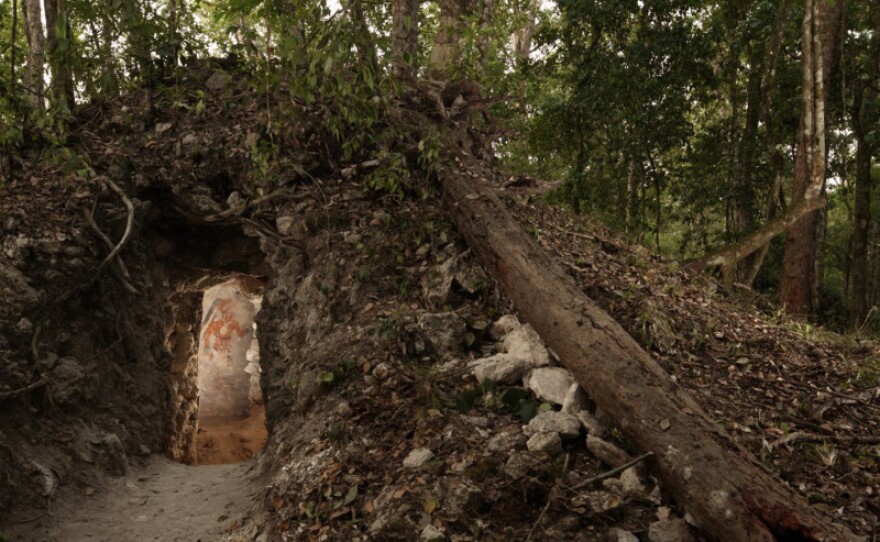 The painted figure of a man — possibly a scribe who once lived in the house built by the ancient Maya — is illuminated through a doorway to the dwelling, in northeastern Guatemala. The structure represents the first Mayan house found to contain artwork on its walls.