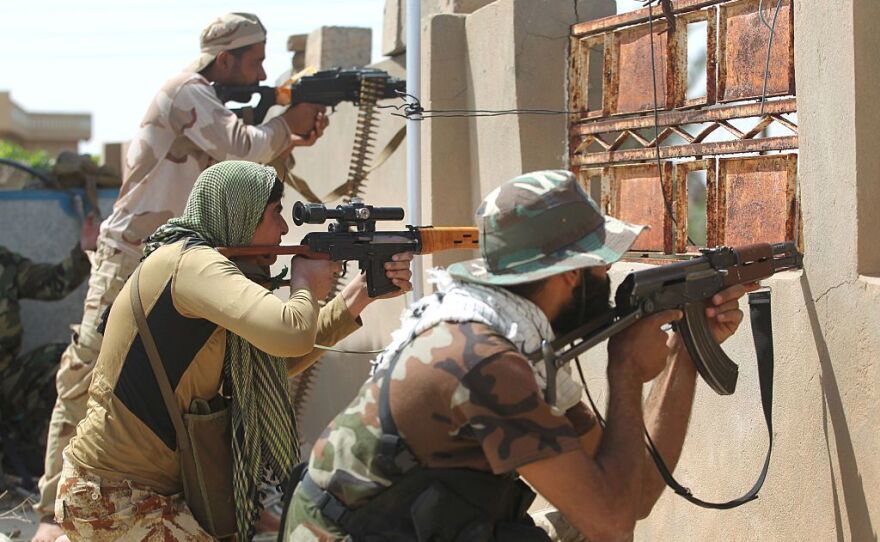 Iraqi pro-government fighters hold position in al-Shahabi village, east of Fallujah, on Wednesday, as part of a major assault to retake the city from Islamic State.