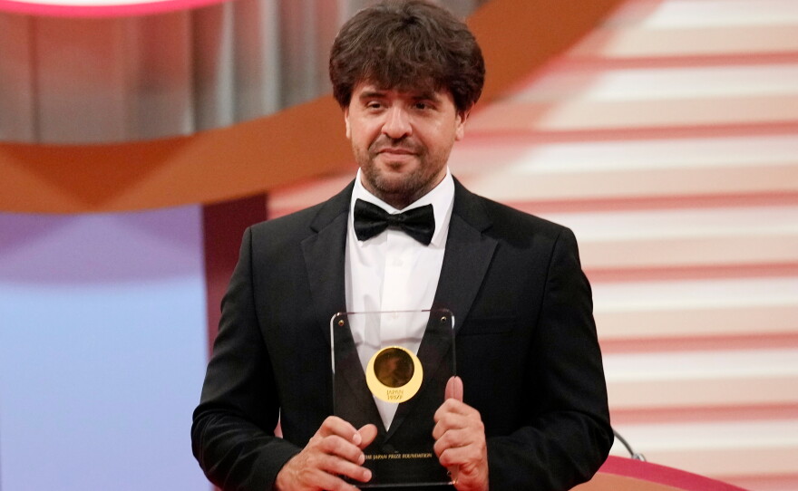 FILE - U.S. scientist Karl Deisseroth, professor of Departments of Bioengineering and Psychiatry at Stanford University, shows his trophy for "Life Sciences" field during the Japan Prize presentation ceremony Thursday, April 13, 2023, in Tokyo.