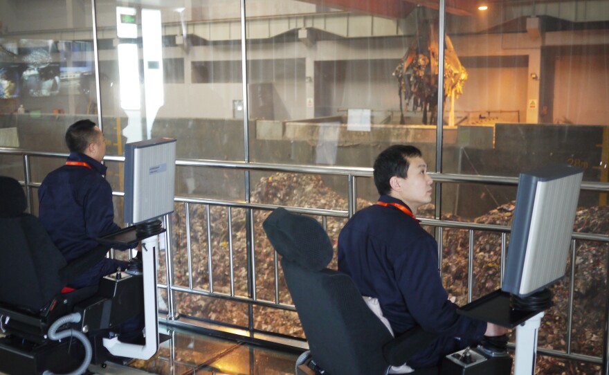 Engineers at Beijing's Gao'antun incinerator power plant control giant claws with joysticks on special chairs inside a cockpit. The claws are capable of lifting eight tons of garbage with each scoop.