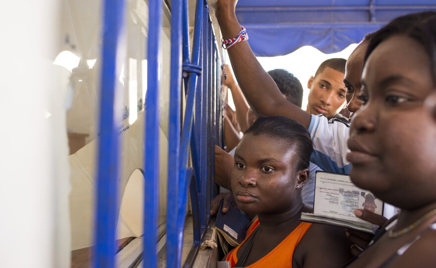 A crowd presses up to a document processing window at the Palace of Justice in San Pedro de Macoris. Many of those waiting in line are Haitian nationals requesting background checks, one of the steps required to "regularize" their status in the Dominican Republic.