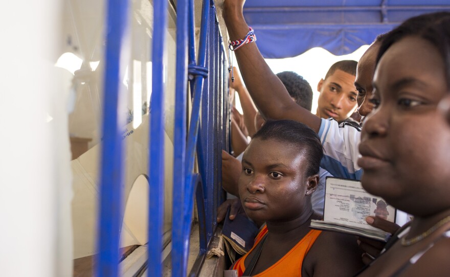 A crowd presses up to a document processing window at the Palace of Justice in San Pedro de Macoris. Many of those waiting in line are Haitian nationals requesting background checks, one of the steps required to "regularize" their status in the Dominican Republic.