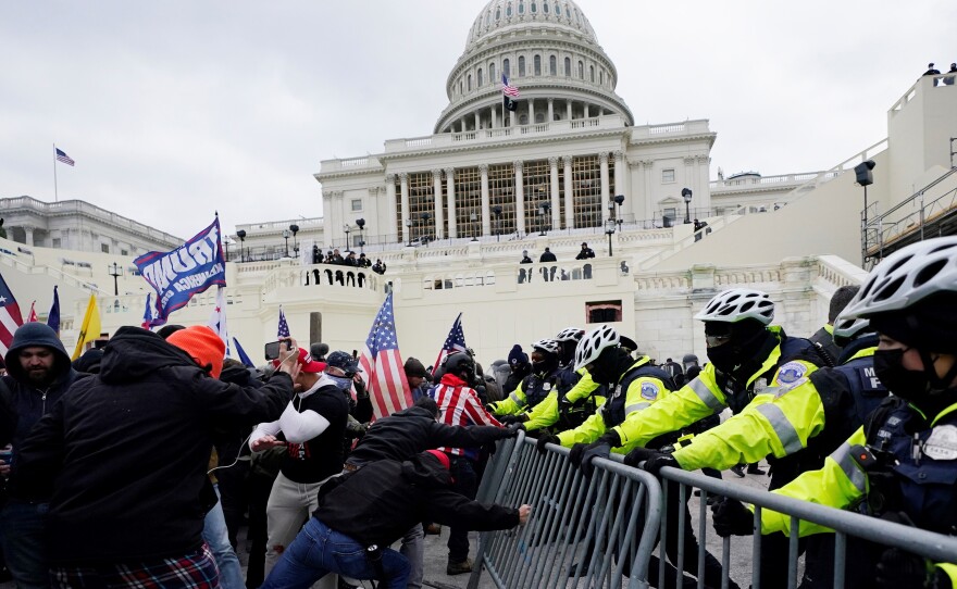 In this Wednesday, Jan. 6, 2021 file photo, Trump supporters try to break through a police barrier at the Capitol in Washington, D.C.