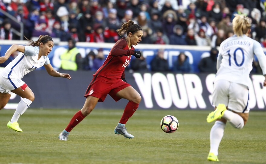 United States midfielder Carli Lloyd (center) moves the ball upfield against England during the first half of a SheBelieves Cup match on March 4 in Harrison, N.J. England won the match, 1-0.
