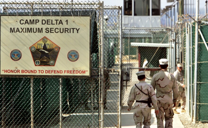 In this June 27, 2006, file photo U.S. military guards walk within Camp Delta at the Guantanamo Bay U.S. Naval Base, Cuba. The U.S. announced the transfer of four detainees from Guantanamo to Oman; one will go to Estonia.