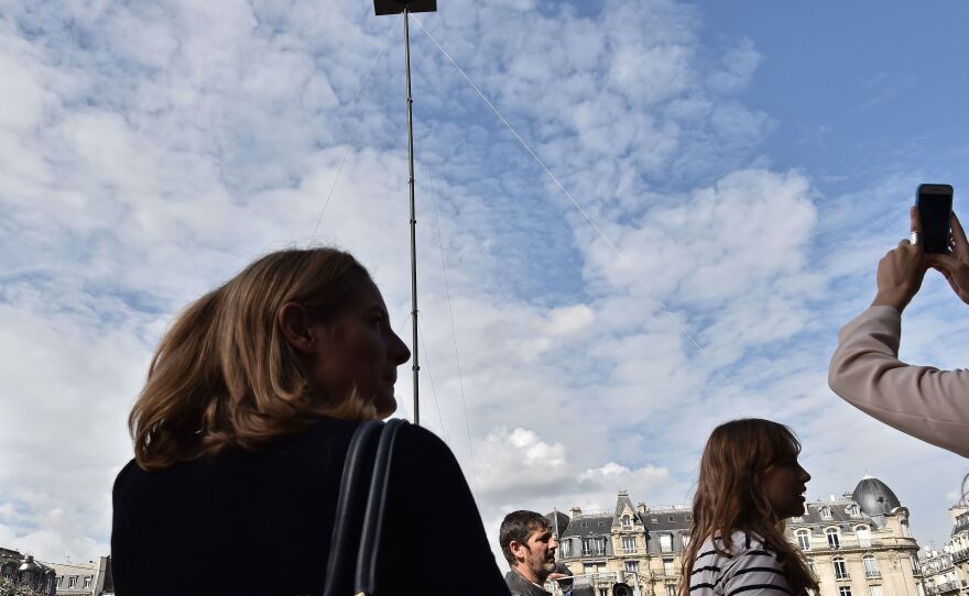 Poincheval sits on a platform placed atop a roughly 60-foot-high pole, as part of his performance outside the Gare de Lyon railway station in Paris last year.