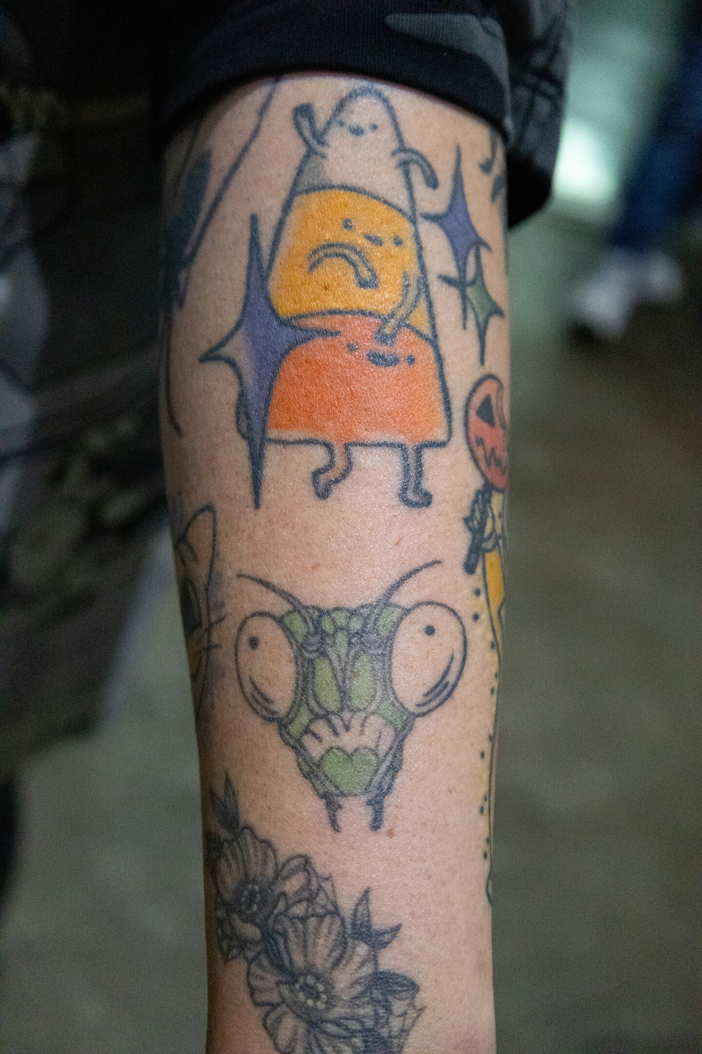 Candy corn and praying mantis tattoos playfully decorate an attendee's arm at Comic-Con, July 23, 2026.