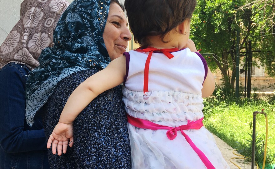 Caregiver Fajriya Khaled holds a child at an orphanage in northeastern Syria, home to 41 children of Yazidi mothers and ISIS fathers. The Yazidi community in Iraq forces the women to leave their children behind if they want to return home.