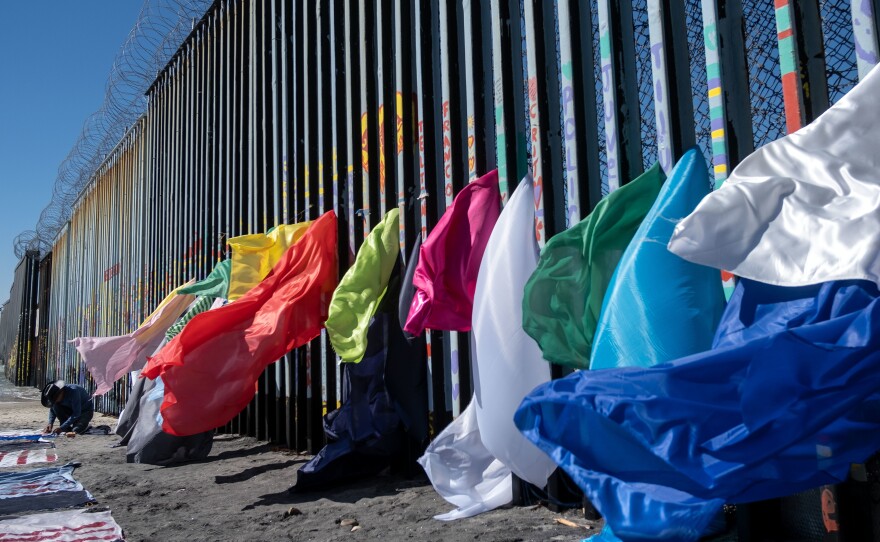 Central American migrant artist Robenz creates an installation on the Mexico-U.S. border fence in Playas de Tijuana, Baja California state, Mexico, on Feb. 24.