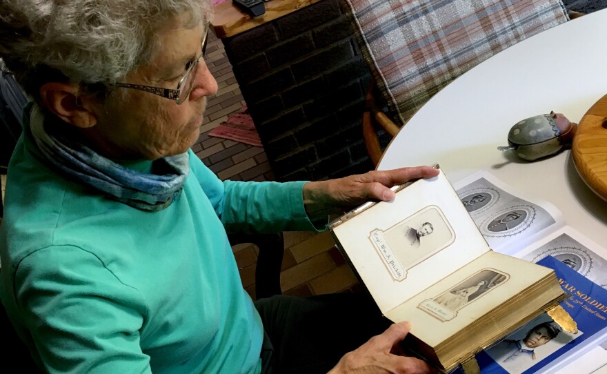 Aneita Atwood Gates looks through an album of her great-grandmother's side of the family, which includes a picture of her great-grandfather William A. Prickitt, seen here.
