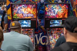 Comic-Con attendees play a Venom-themed pinball game at the Stern Pinball both inside the main exhibit hall, Friday, July 21, 2023.