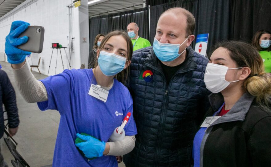 Gov. Jared Polis poses for a selfie with health staffers at a mass vaccination clinic at the National Western Center in Denver on Feb. 6.