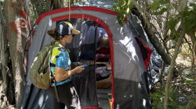 San Diego Riverpark Foundation COO Sarah Hutmacher checks in on a woman experiencing homelessness along the San Diego Riverbed on June 17, 2026.