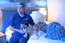 January flood victim Michael Rios and his dog Maxie sitting on their hotel bed in National City, California on May 22, 2024.