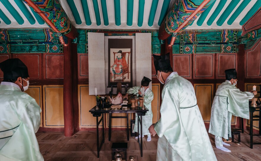 Men check ancestral offerings before the spring ceremony starts at Museong Seowon. A painting of Museong Seowon's venerated scholar, Choe Chi-won, a celebrated poet and scholar of Silla kingdom, looks over the offering table.