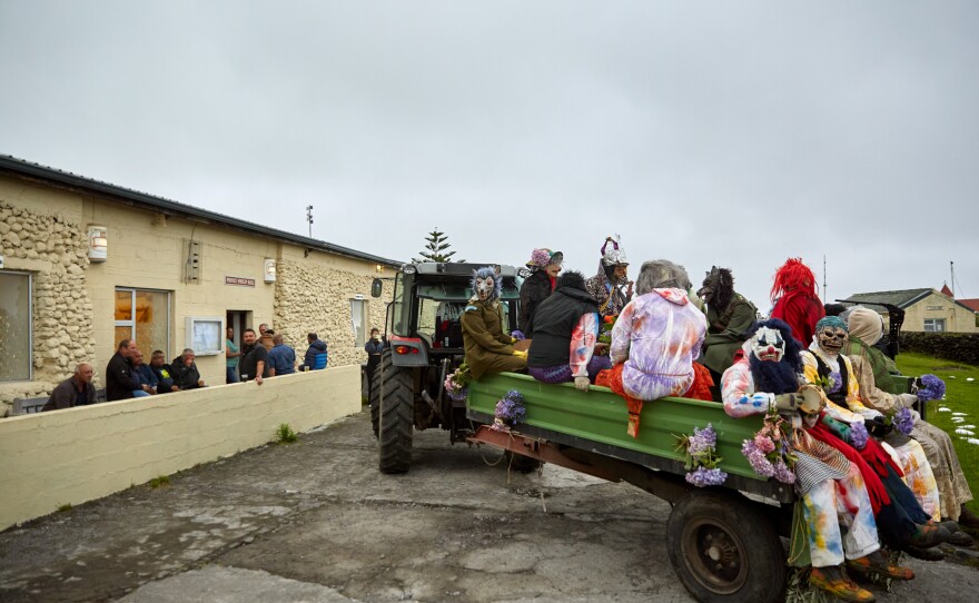 The Okalolies' tractor arrives at the Prince Phillip Hall, home to the village's town hall and the only pub on the island, to deliver King Charles and his queen. After they've roamed around the community for a few hours, the Okalolies pick up a tractor and trailer to collect the wife of the U.K.'s representative on the island, as well as the wife of the Chief Islander.