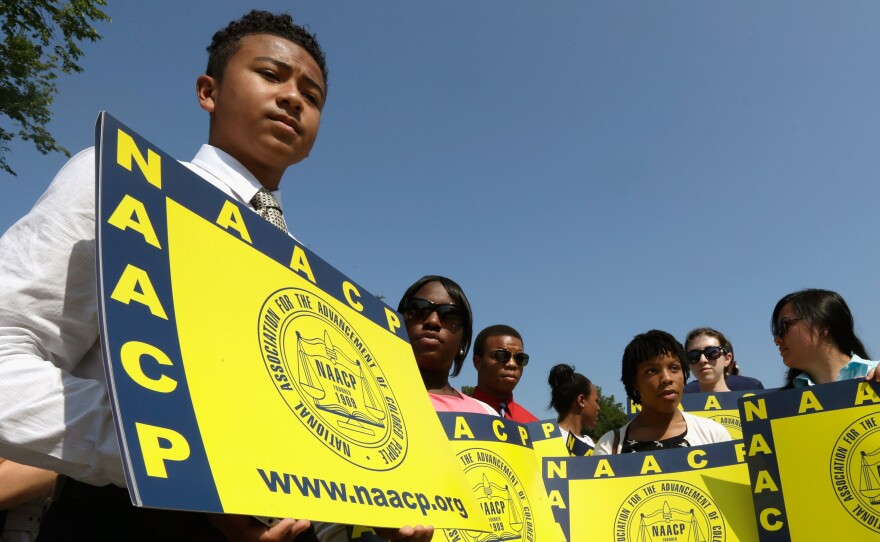 Supporters of the NAACP hold signs outside the Supreme Court building on Tuesday. The court ruled that Section 4 of the Voting Rights Act, which aimed at protecting minority voters, is unconstitutional.