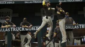San Diego Padres' Fernando Tatis Jr., center left, and Jurickson Profar, center right, leap and celebrate in front of the dugout after Tatis Jr., hit a three-run home run in the seventh inning of a baseball game against the Texas Rangers in Arlington, Texas, Monday, Aug. 17, 2020. 

