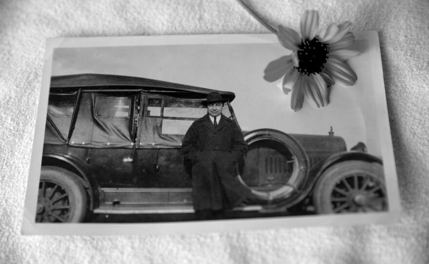 John B. McGillis stands in front of an early automobile, in an unknown location. His great granddaughter says McGillis truly embodied a duality of existence, as his knowledge of traditional customs and beliefs intersected with his ability to adapt to the rapid modernization of the times.