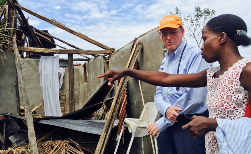Dr. Paul Farmer, co-founder of Partners In Health, stands with Mirlande Estenale in front of what used to be her home in the town of Les Cayes, Haiti. He visited Haiti, a country where his group has worked to improve health care, in the aftermath of Hurricane Matthew in 2016.
