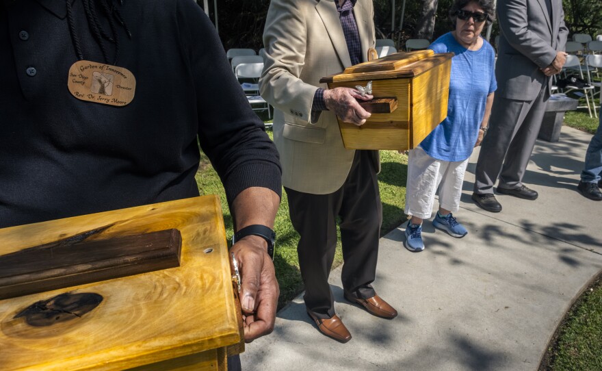 Each person in attendance holds the tiny coffin, one after the other, to honor the abandoned child who is being laid to rest at the Garden of Innocence, San Diego, June 17, 2023.<br/>