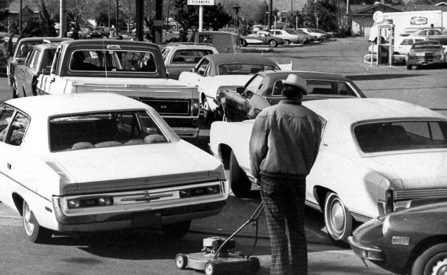 Drivers and a man pushing a lawnmower line up at gas station in San Jose, Calif., on March 15, 1974.