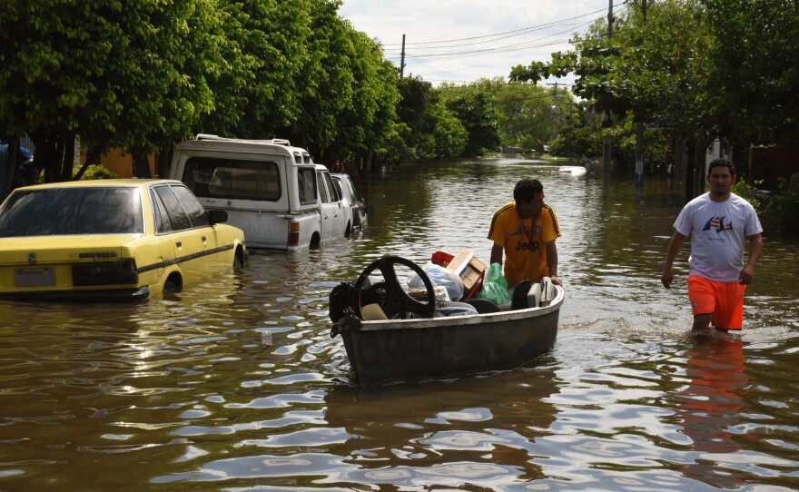 Locals recover belongings in a flooded neighborhood in Paraguay's capital, Asuncion, on Thursday.