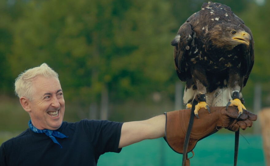 Alan Cumming holds an eagle
