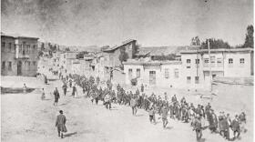 Armenian people are marched to a nearby prison in Mezireh by armed Ottoman soldiers. Kharpert, Ottoman Empire, April 1915. Published by the American red cross, it was first published in the United States prior to Jan. 1, 1923.