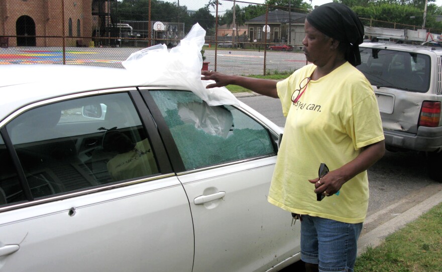 Debra Hunter shows off the bullet holes and damage to her car after a gunfight near her New Orleans home. Police say one of the two people arrested used an AK-47 assault rifle in the incident, which occurred on a weekday during lunch hour, not far from a police station and New Orleans City Hall.