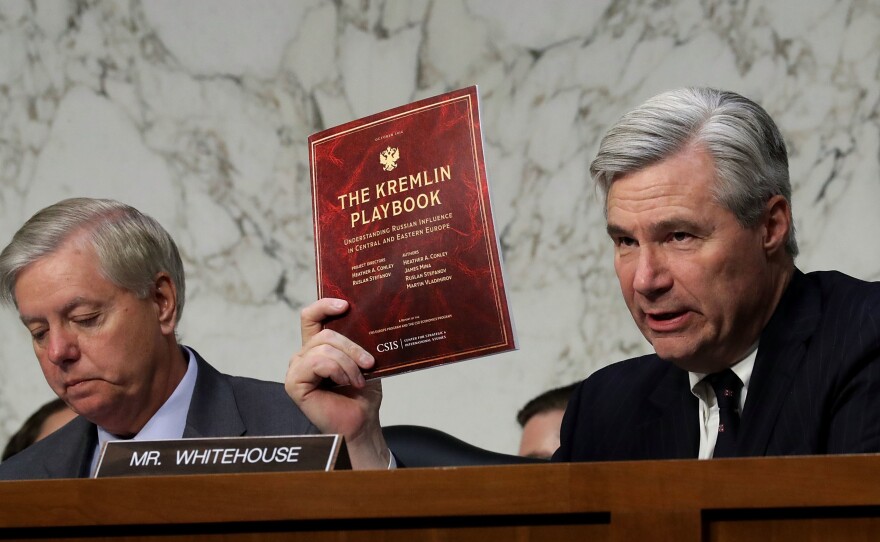 Senate Judiciary Committee member Sen. Sheldon Whitehouse, D-R.I., holds up a copy of The Kremlin Playbook while delivering remarks with Sen. Lindsey Graham, R-S.C., (left) at the conclusion of a subcommittee hearing on Russian interference in the 2016 election on May 8, 2017.