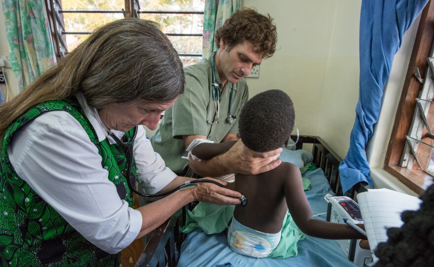 Dr. Terrie Taylor, left, and Dr. Karl Seydel take a child's vitals in the malaria ward at Queen Elizabeth Hospital in Blantyre, Malawi.