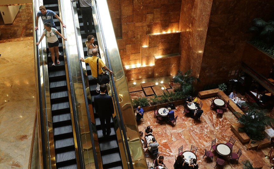 People walk through Trump Tower in New York City in August. Condo prices in the building have fallen, according to journalist and author Tim O'Brien.