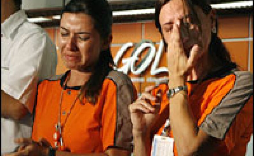 Employees of Gol Airlines cry at Brasilia's international airport while paying homage to the victims in the crash of Flight 1907.