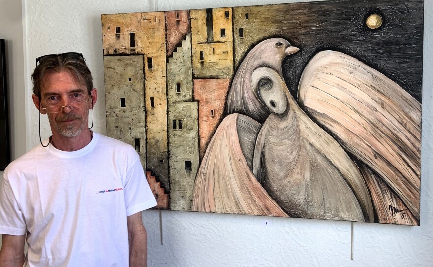 Yuri Mazurenko fled with his wife and their dog and cat from the Ukrainian city of Chernihiv to France. Now he is able to exhibit his art, including this painting called <em>Guard</em>, at the local tourism office in a village in Burgundy.