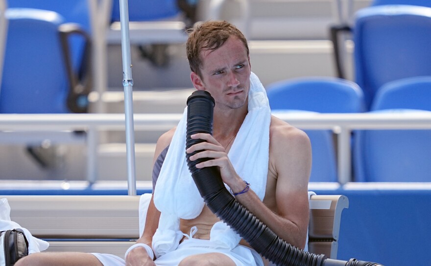 Daniil Medvedev cools down during the break with air from a mobile air conditioner and a towel with ice cubes at the Tokyo Olympics.